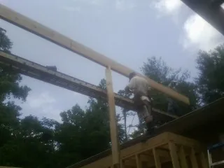 Carpenter setting a ridge beam over a new addition frame — Ice Dam Removal by Roofing Brothers in Hemet