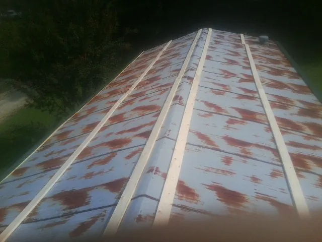 Rusted metal roof panels with new wood purlins before replacement — Storm Damage Roof Repair in Hemet by Roofing Brothers
