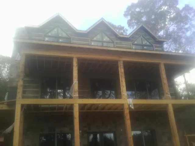 Dormers and porch framing on a large log home under construction — Roof Coating work by our crew in Hemet